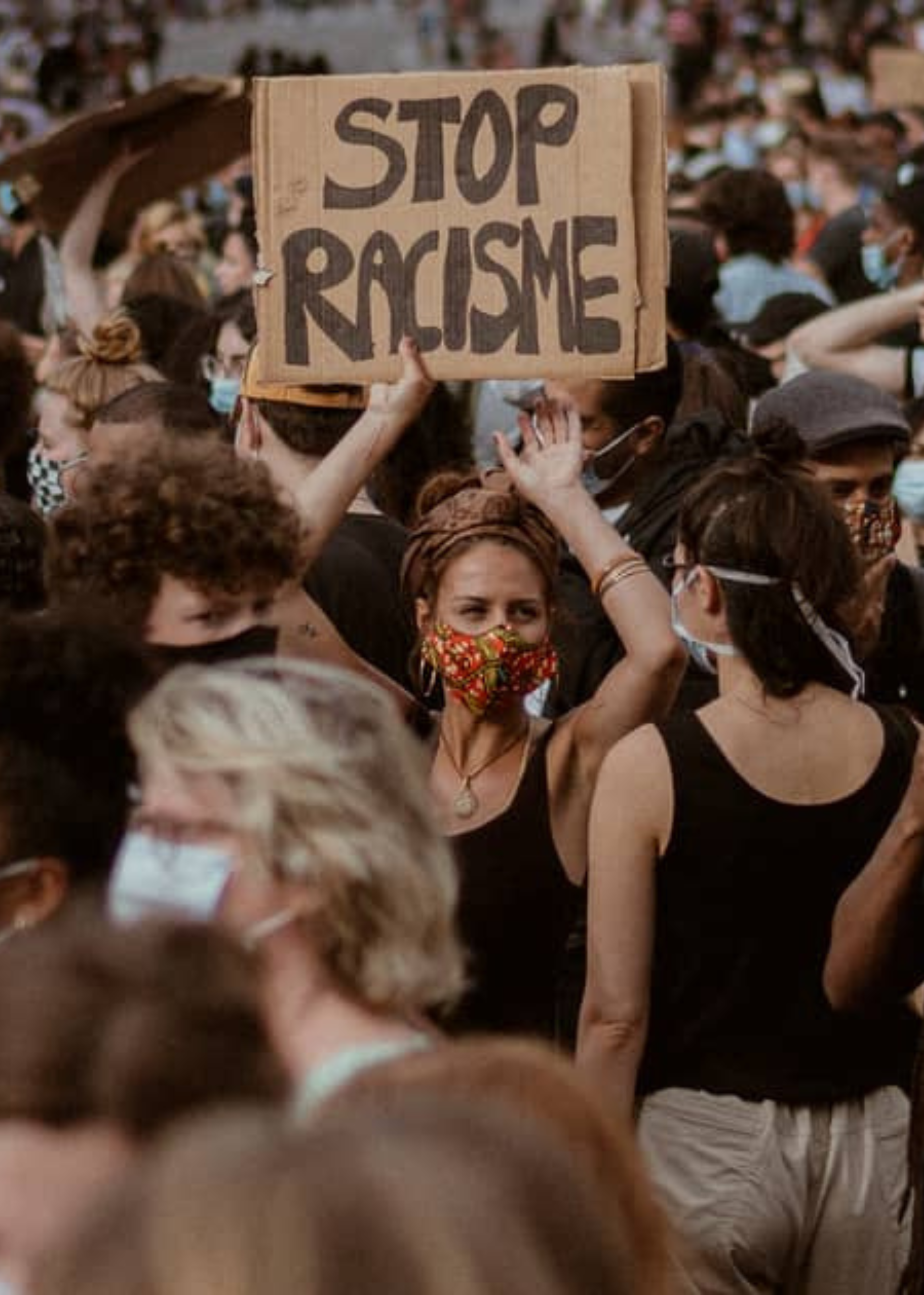 Vrouw houdt bord op tijdens demo: Stop racisme