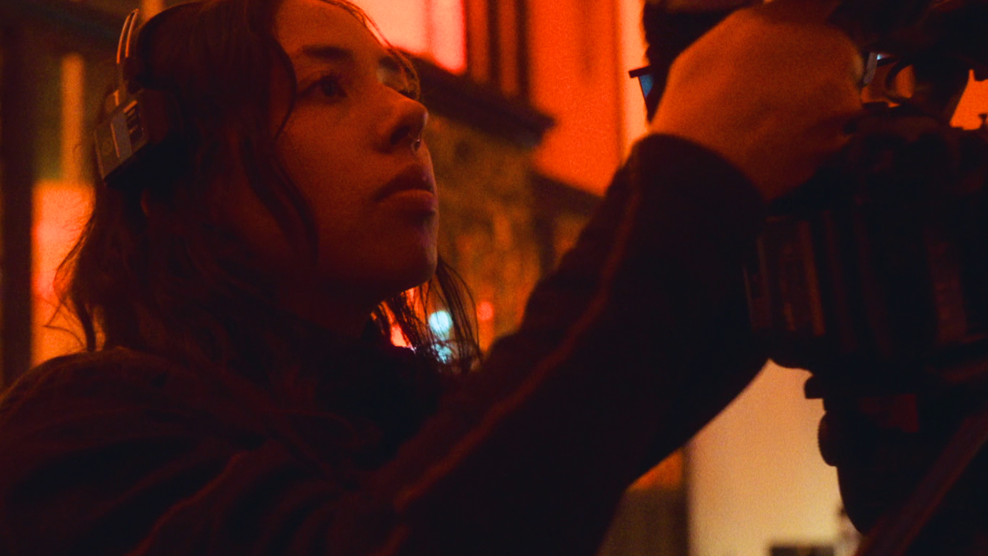 Een vrouw achter een filmcamera.